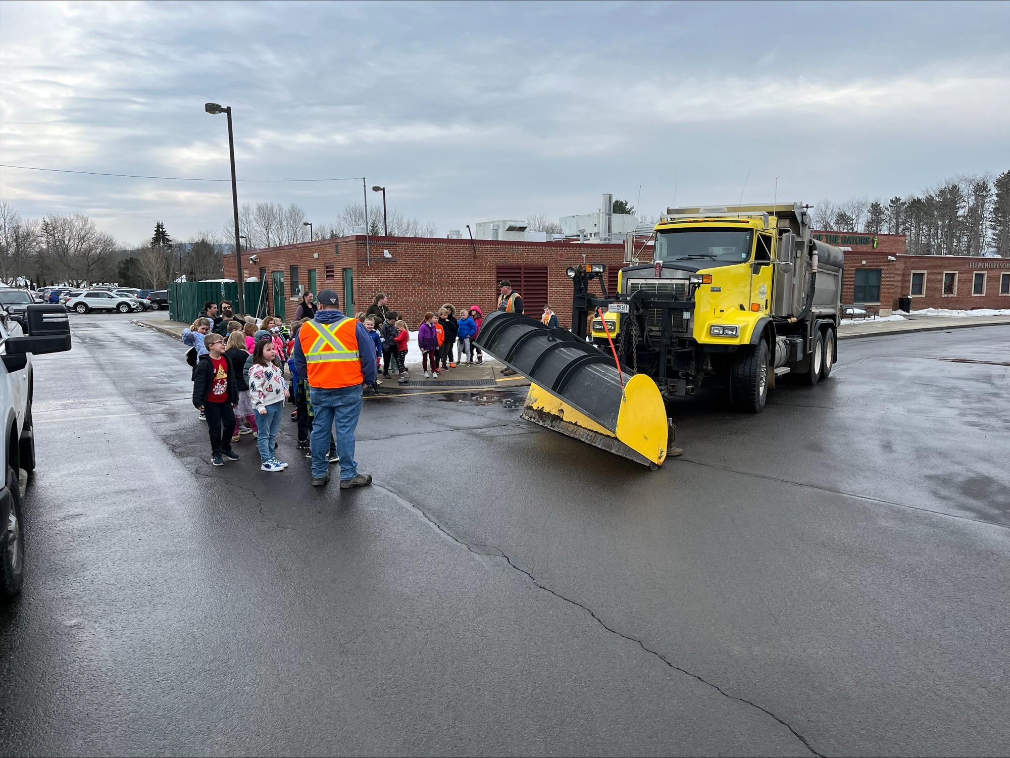 Students talking to workers by the plow truck